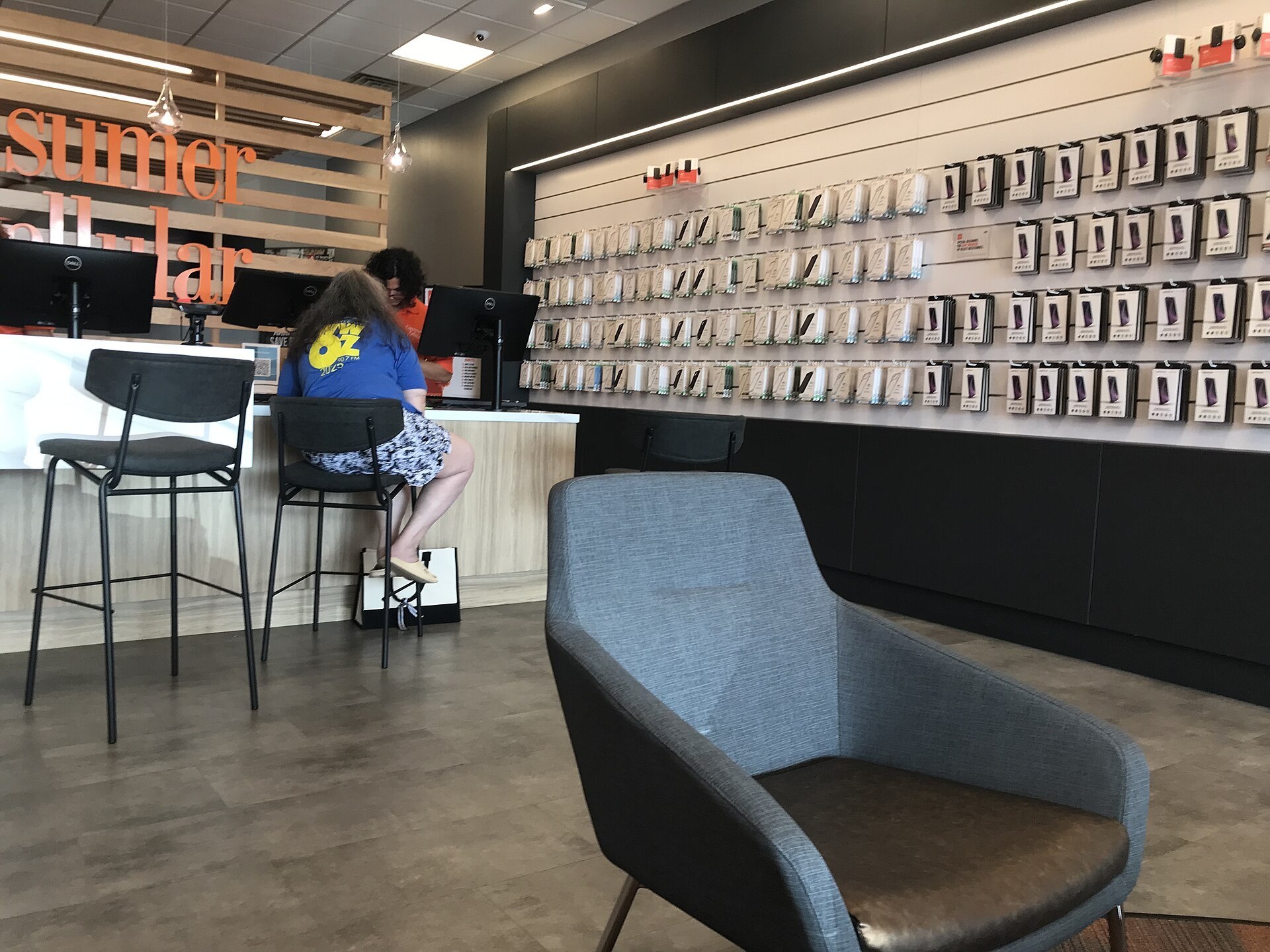 Consumer Cellular shop, Metairie Louisiana, interior 2026. Original caption: "Ms H upgrading her smartphone" (Consumer Cellular)